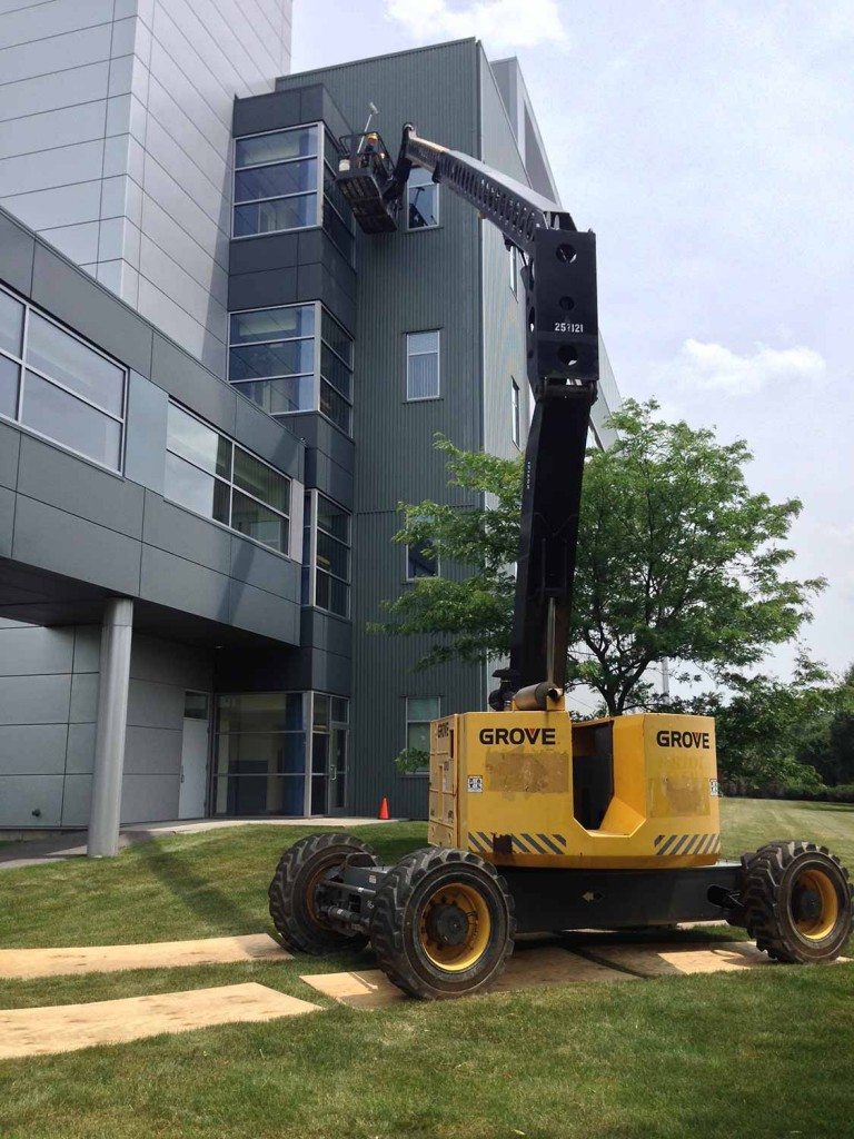 Window cleaning building using man lift