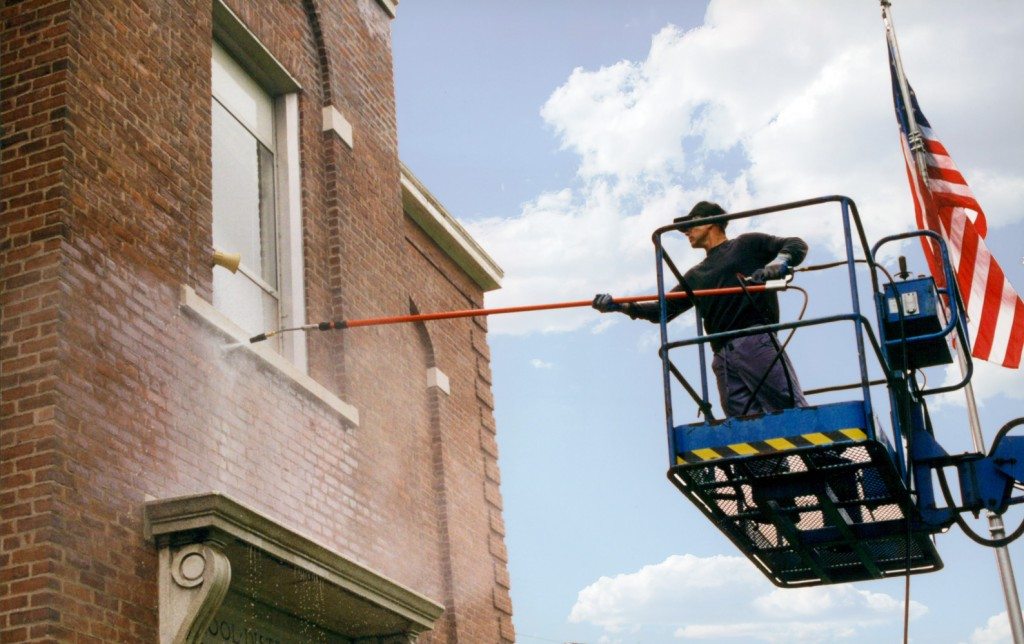 Power washing brick on building